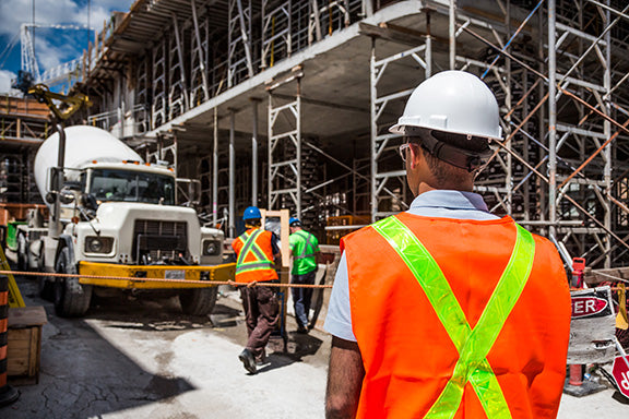 Construction Inspector watching workers on a construction site.
