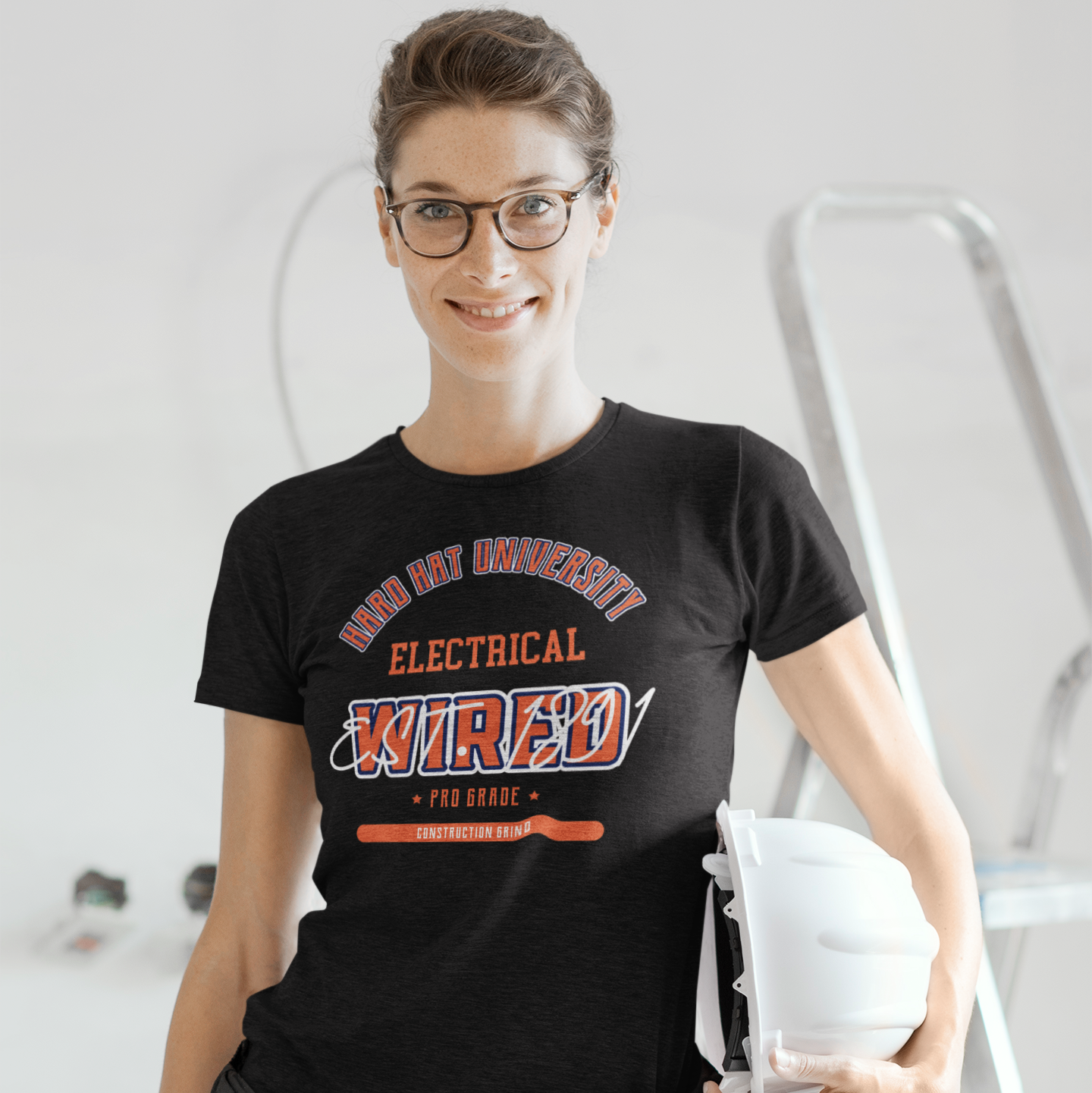 The Construction Grind “Hard Hat University” Electrician's Trade T-Shirt features 'Electrical – Wired' in bold college sports style lettering, paying tribute to the skill & professionalism that builds our world. The “Established” date represents the year the trade was formally recognized in the U.S. The 'PRO-GRADE' stamp adds a touch of authenticity and pride. Design is featured on a black Gildan 5000 short-sleeved T-Shirt made with 100% U.S. cotton. Heavy Cotton 5.3 oz/y.