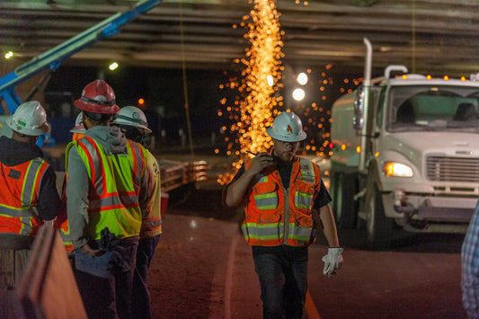 A hard working construction crew wearing safety gear working hard on their job site.