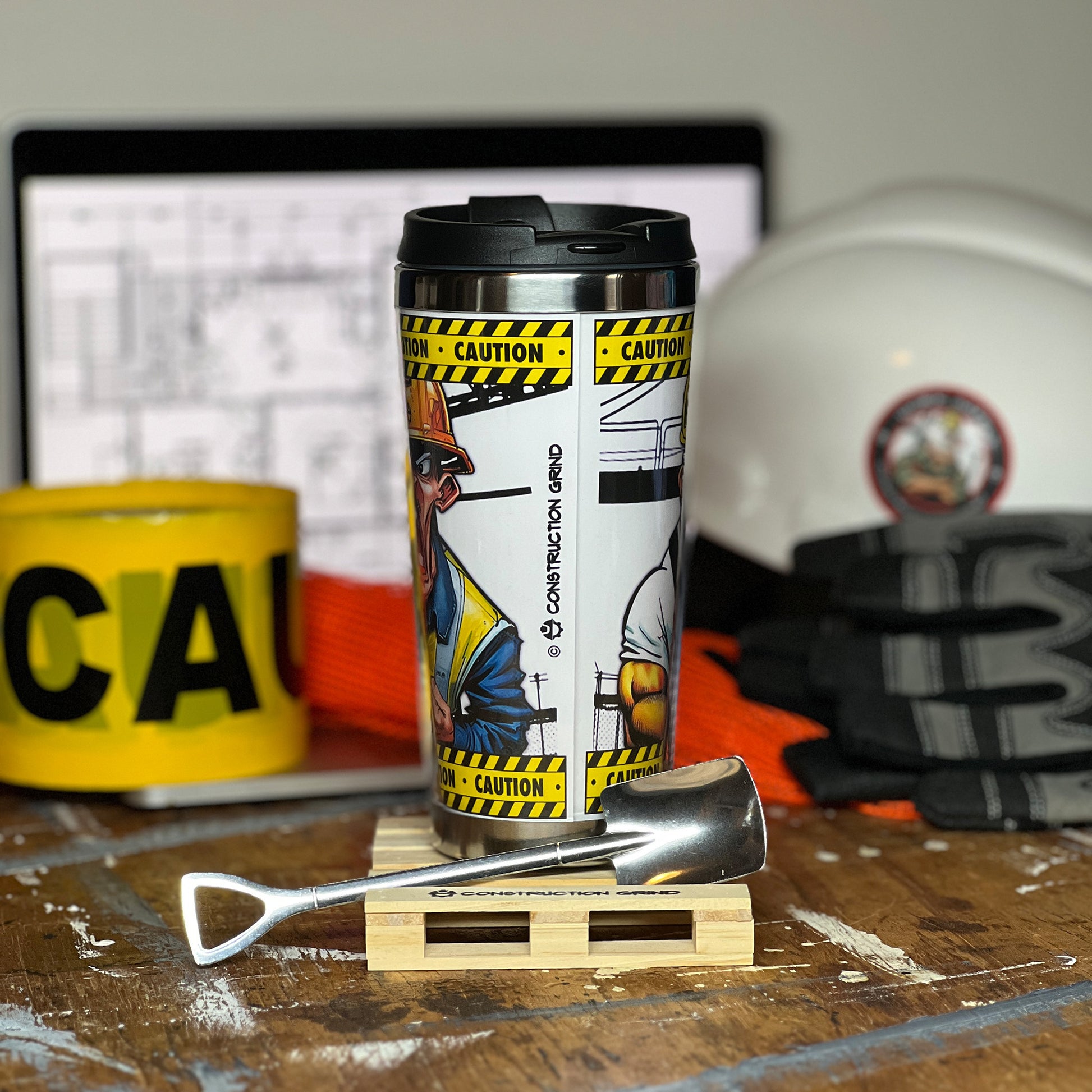 Construction Grind's "Meet the Crew" First Shift 12 oz. coffee tumbler sitting on a 4" wooden pallet coaster. Showing the rear image seam and our logo.