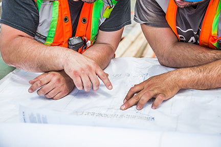 Two construction workers reviewing building plans.