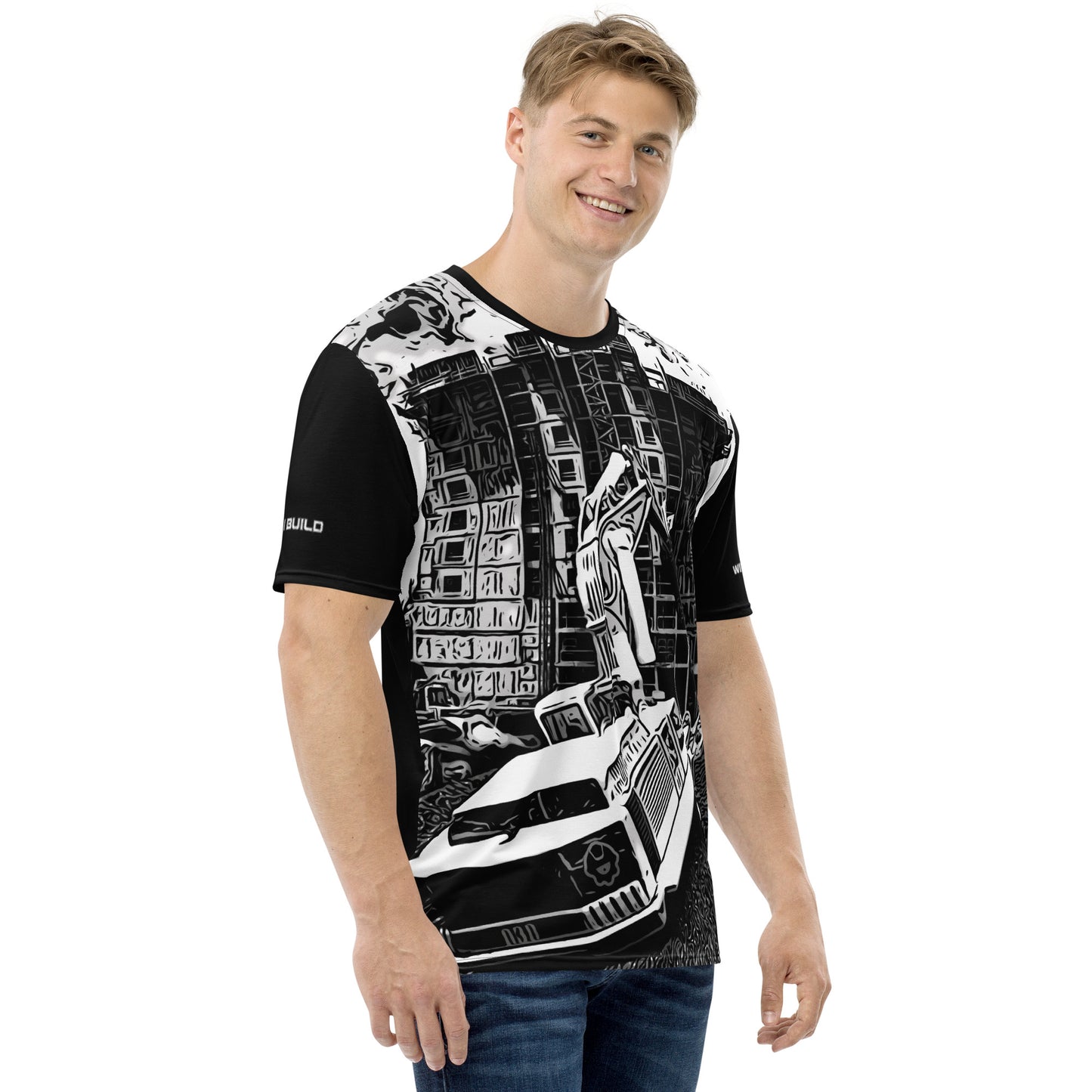 A man wearing our Construction Grind Dig Alert all-over print short-sleeved t-shirt in black and white style, shown from the right-hand view. The image reveals the detailed main graphic of a dump truck in action on a construction site, and the right sleeve displays a white 'I Build' graphic. The design emphasizes bold construction imagery on a premium tee.