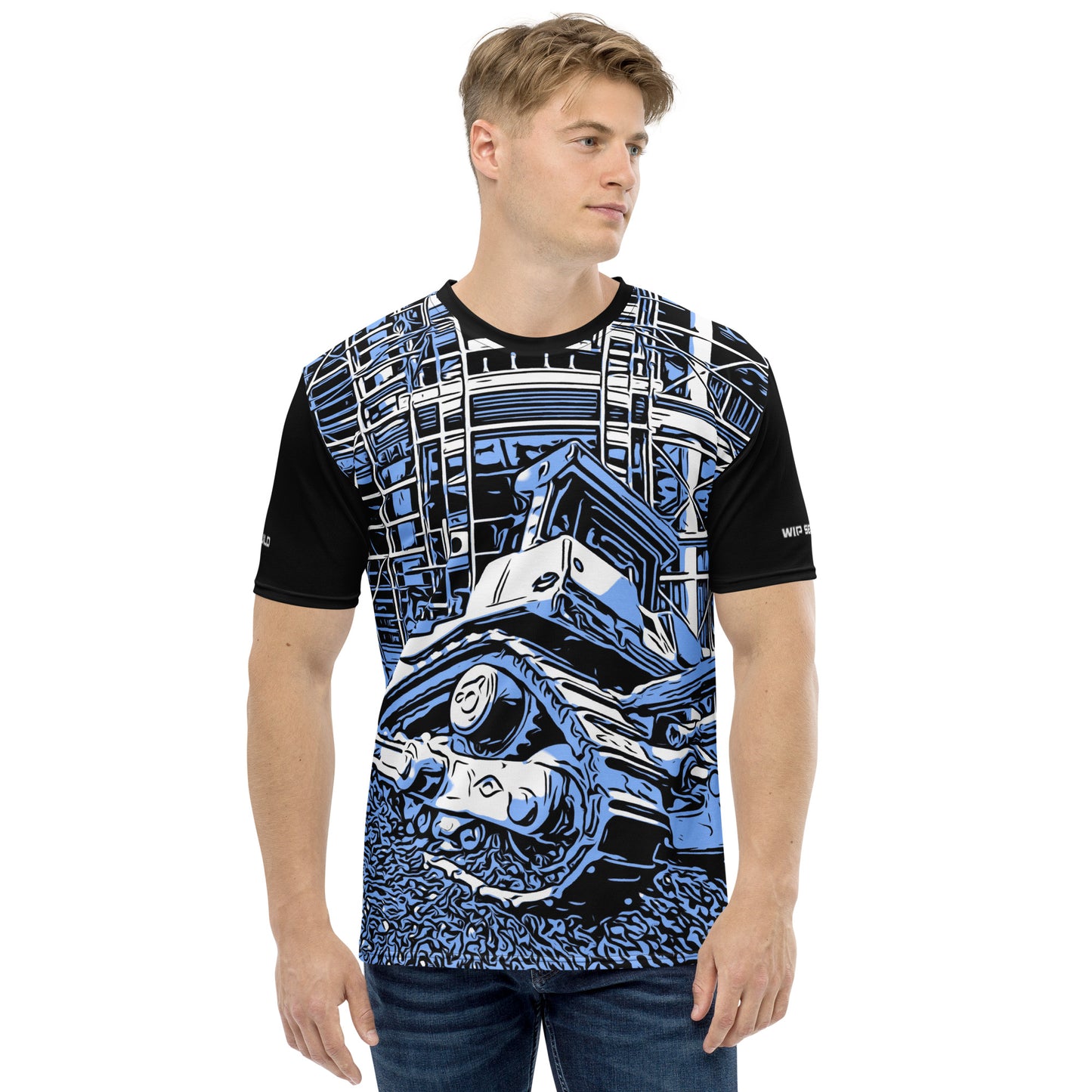 A man wearing our Construction Grind Dozer Duty all-over print short-sleeved t-shirt in our blue jeans style, shown from the front. The main graphic features a large bulldozer actively pushing dirt at a construction site in front of a building under construction, highlighting dynamic construction imagery. The design is printed in vibrant colors on a premium, all-over print tee.