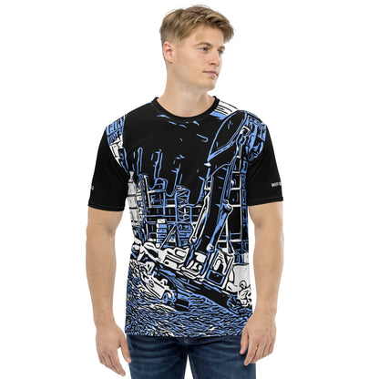 A man wearing our Construction Grind Super Scooper all-over print short-sleeved t-shirt in our blue jeans style, shown from the front. The main graphic features a large excavator with the shovel front and center, digging at a construction site in front of a building under construction, highlighting dynamic construction imagery. The design is printed in vibrant colors on a premium, all-over print tee.