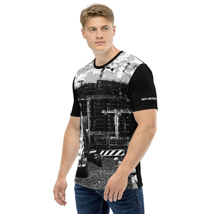 A man our wearing Construction Grind Trenching all-over print short-sleeved t-shirt in black and white style, shown from the left-hand view. The image reveals the detailed main graphic of a backhoe in action on a construction site, and the left sleeve displays a white 'WIP SERIES' graphic. The design emphasizes bold construction imagery on a premium tee.